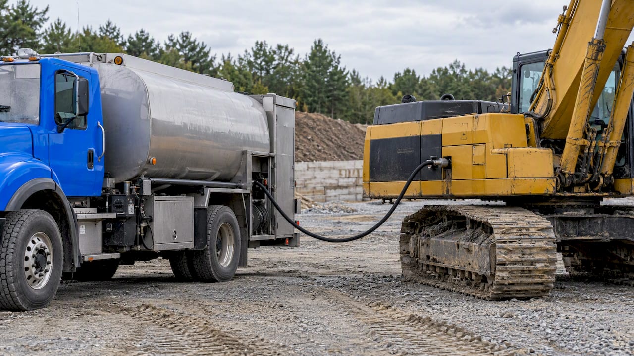 Mobile fuel truck fueling a parked excavator